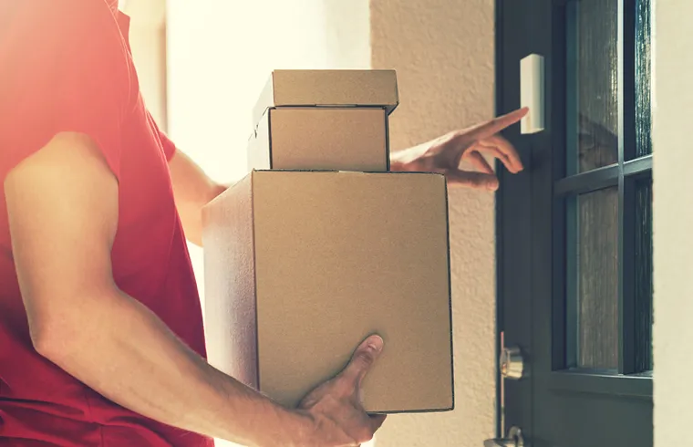 Entregador chegando com encomenda em frente uma porta blindada com fechadura digital